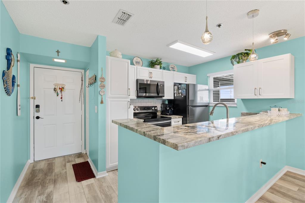 5722 Biscayne Court, Unit 308 New Port Richey, FL 34652 - Photo 6 of 31 a kitchen with kitchen island a counter top space appliances and cabinets