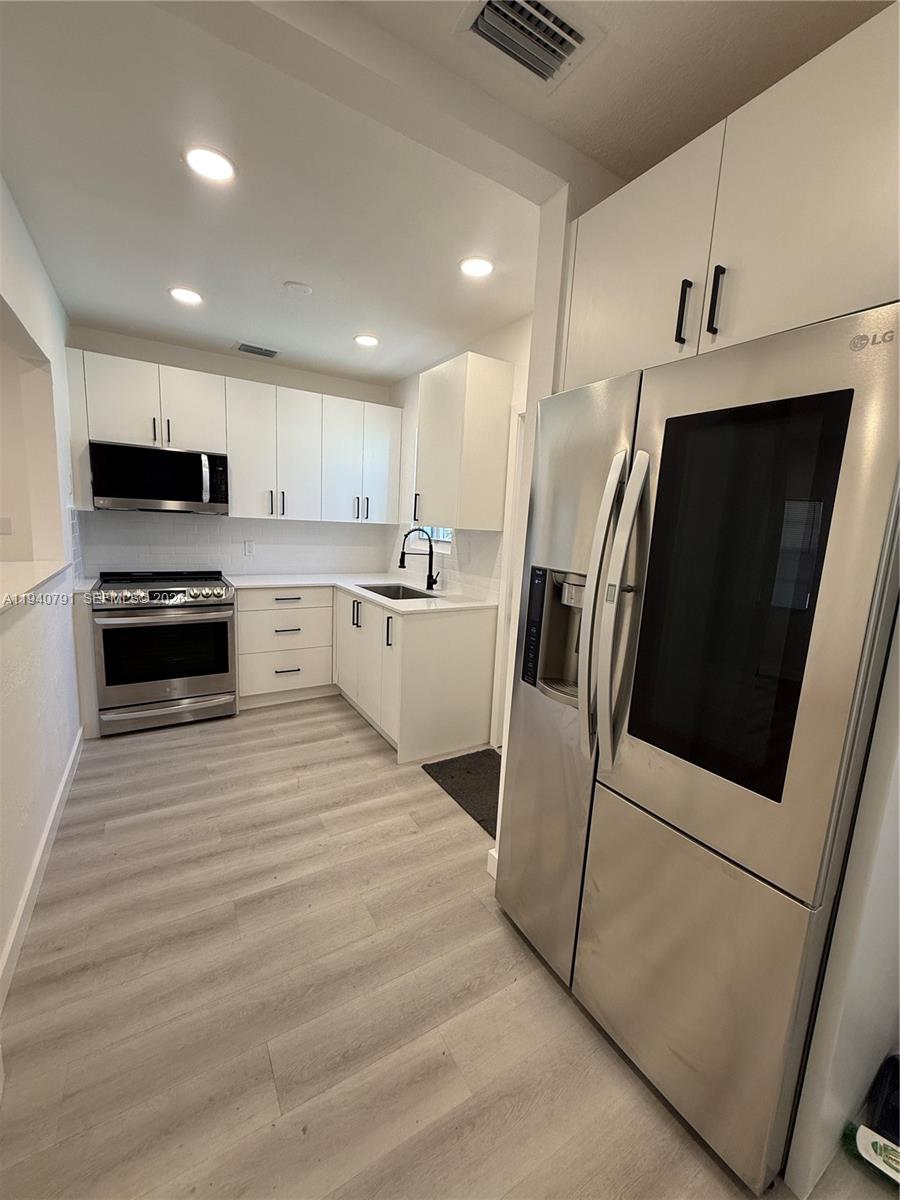 4020 Northwest 12th Avenue Miami, FL 33142 - Photo 2 of 13 a kitchen with stainless steel appliances a refrigerator sink and microwave
