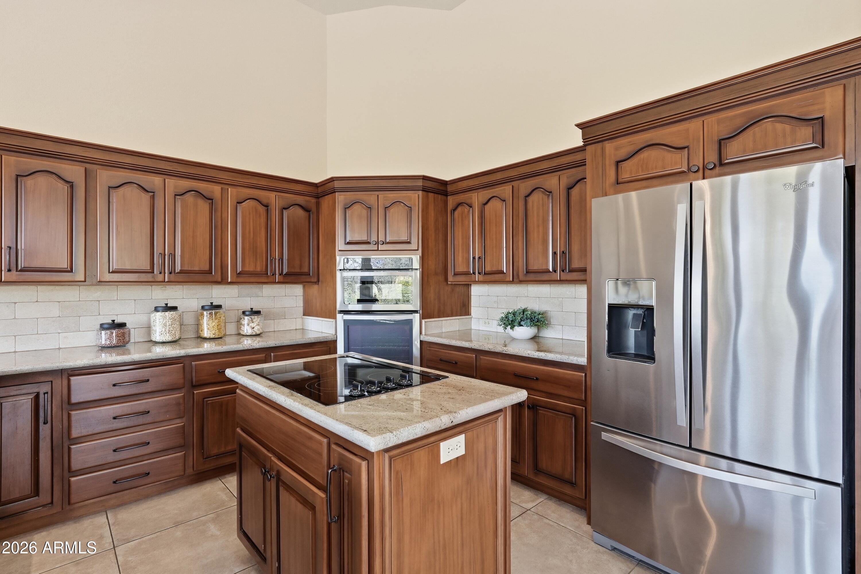 18602 Amarado Circle Rio Verde, AZ 85263 - Photo 12 of 58 a kitchen with granite countertop a refrigerator and a stove top oven