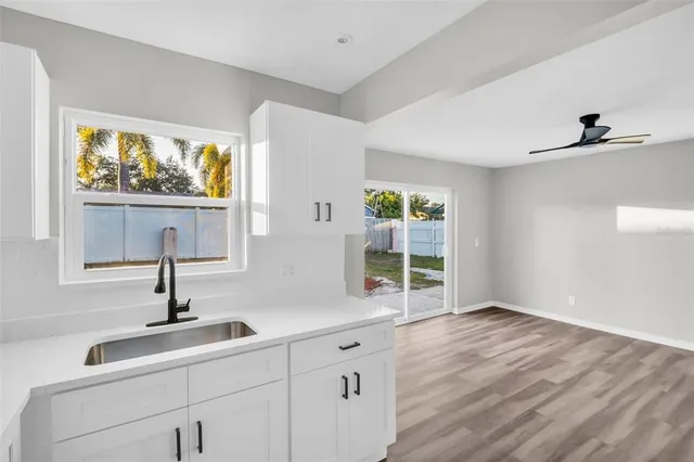 a view of cabinets a sink and dishwasher with wooden floor