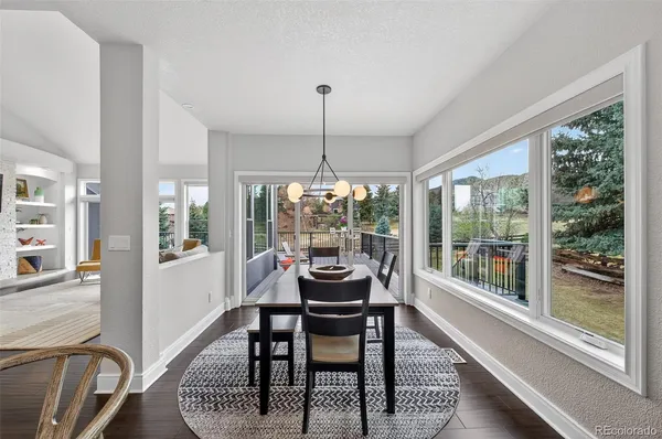 a dining room with furniture large windows and wooden floor