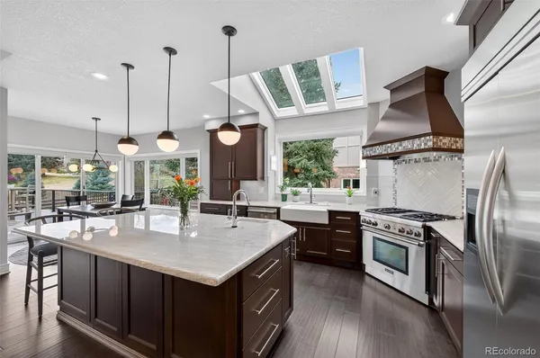 a kitchen with stainless steel appliances granite countertop a stove a sink and a refrigerator