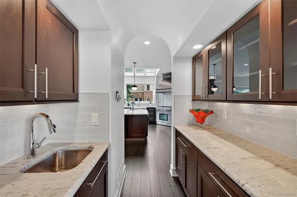 a kitchen with a sink dishwasher a stove and a refrigerator with wooden floor