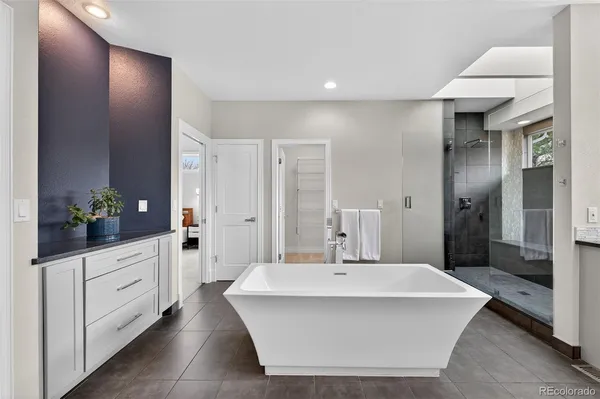 a bathroom with a bathtub shower sink and mirror