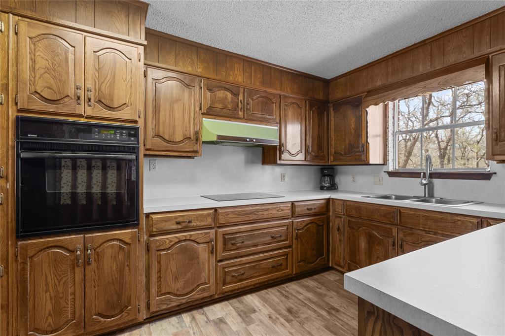 1447 Red Gate Road Mart, TX 76664 - Photo 29 of 38 a kitchen with stainless steel appliances granite countertop a sink and cabinets