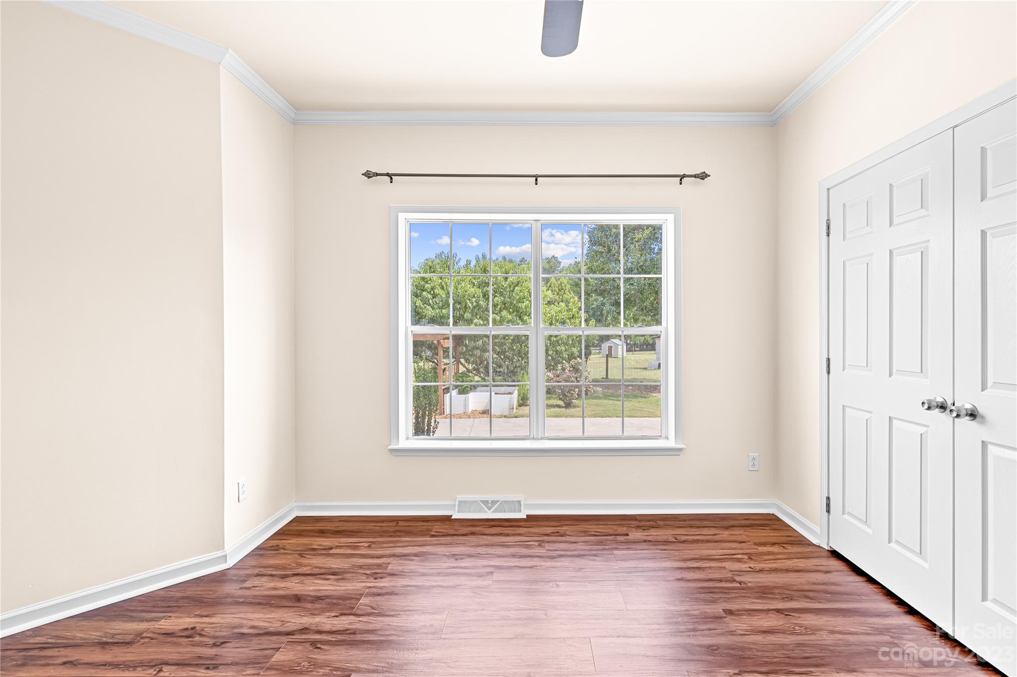 1131 Sikes Mill Road Monroe, NC 28110 - Photo 38 of 43 an empty room with wooden floor and windows