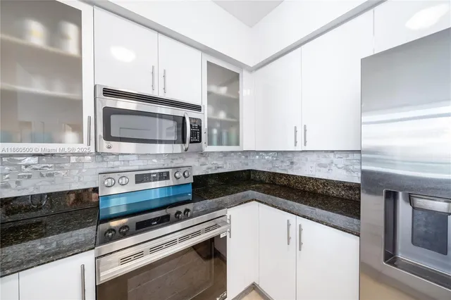 a kitchen with granite countertop a stove microwave and sink