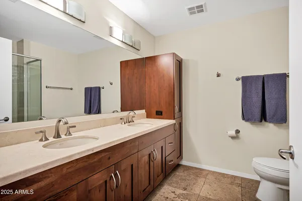 a bathroom with a double vanity sink and a toilet