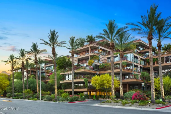 a front view of multi story residential apartment building with yard and sign board