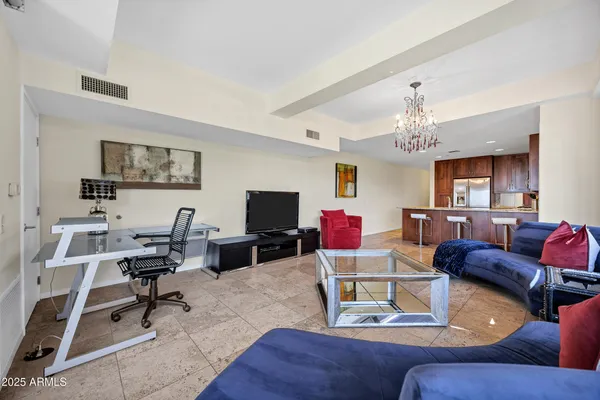 a living room with furniture kitchen view and a chandelier