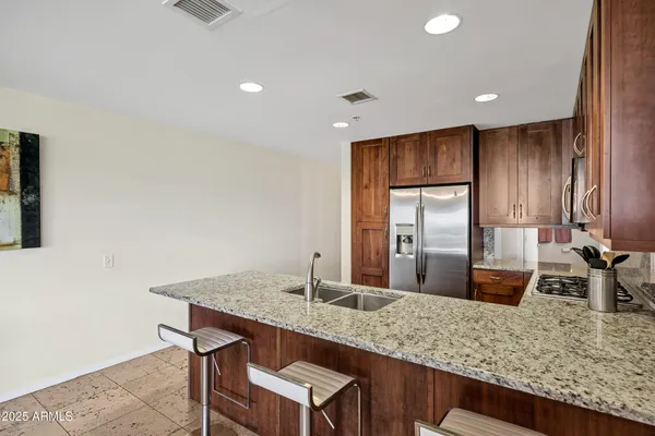 a kitchen with granite countertop a sink and wooden cabinets