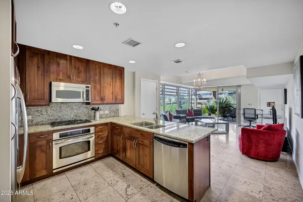 a kitchen with kitchen island granite countertop a sink stove and cabinets