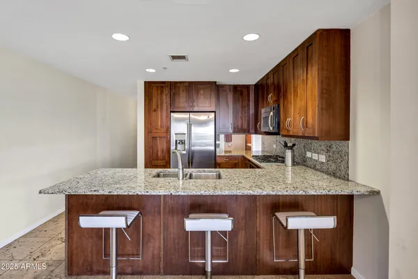 a kitchen with kitchen island granite countertop wooden cabinets and a granite counter tops