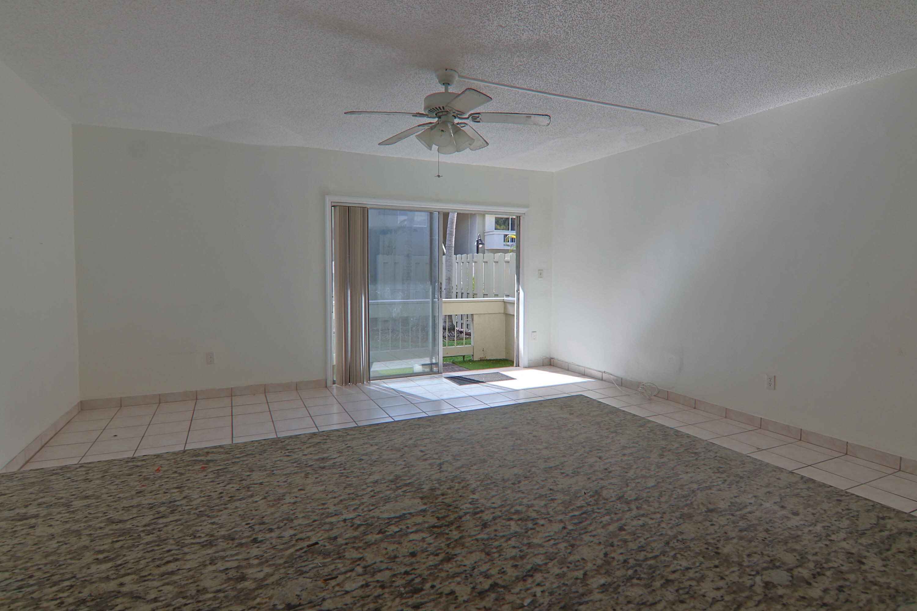9360 Southwest 87th Avenue, Unit N8 Miami, FL 33176 - Photo 4 of 15 an empty room with a empty space and chandelier fan