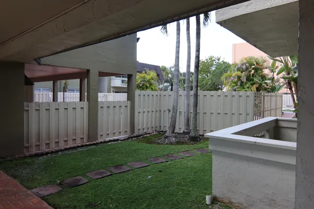 a view of backyard with barbeque grill and wooden fence