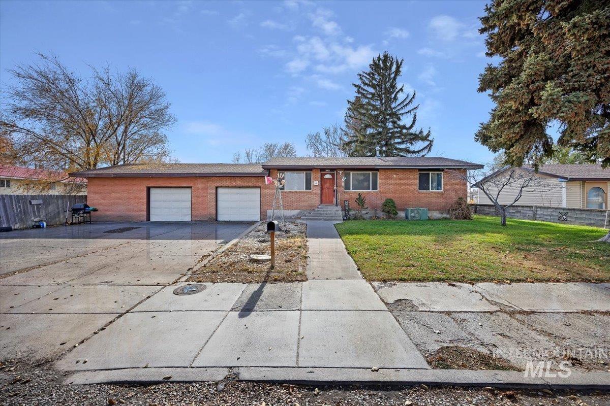 Ranch-style house featuring brick siding, driveway, and a garage