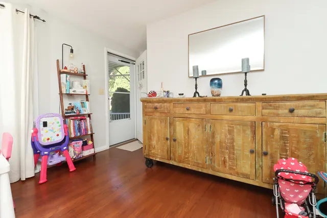 a living room with baby crib furniture and a wooden floor