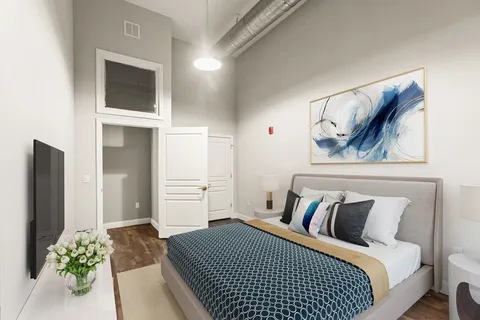 a bedroom with a bed and a painting on the wall