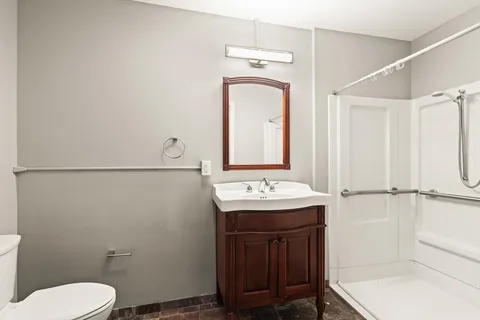 a bathroom with a sink a toilet and mirror