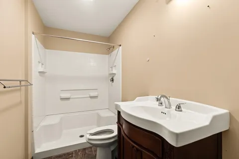 a bathroom with a sink toilet and shower