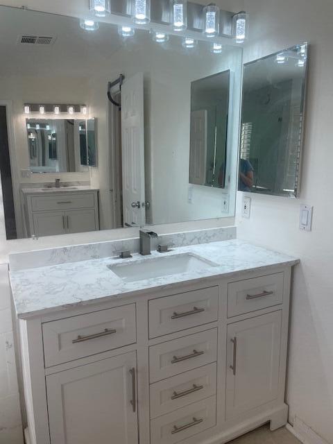 31675 Victor Road Cathedral City, CA 92234 - Photo 5 of 17 a bathroom with a granite countertop sink a large mirror and a