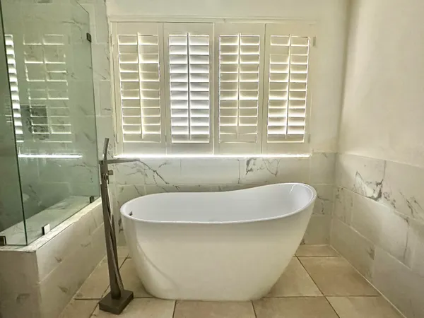 a bath tub sitting in a bathroom next to a window