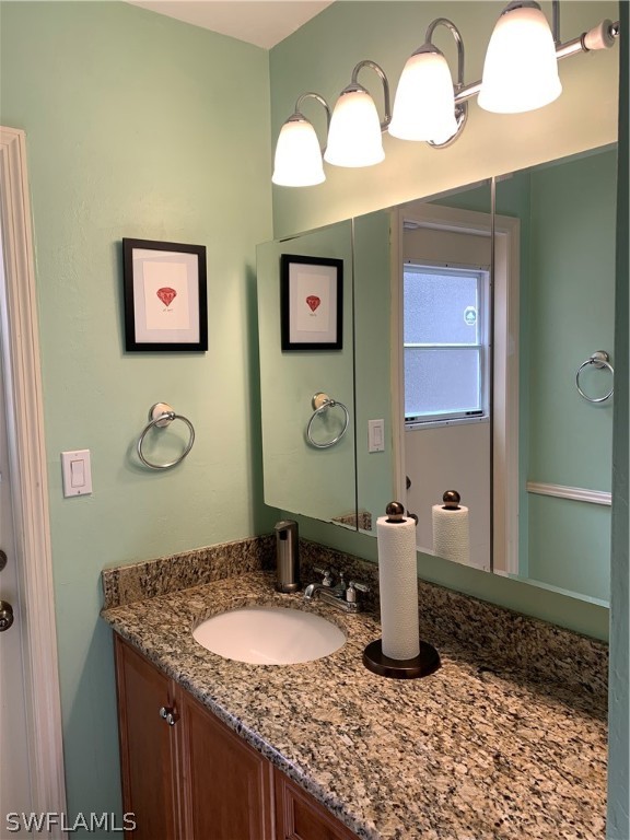 17560 Lee Road Fort Myers, FL 33967 - Photo 22 of 34 a bathroom with a granite countertop sink and a mirror