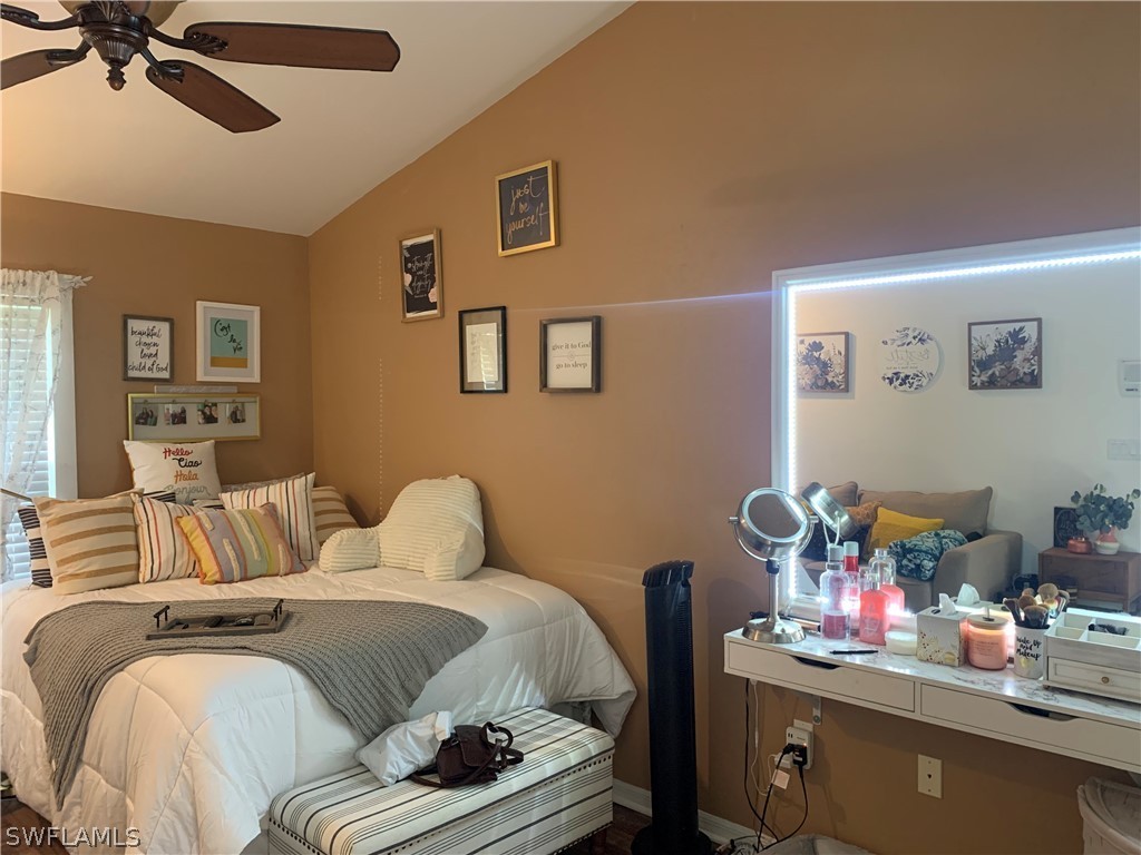17560 Lee Road Fort Myers, FL 33967 - Photo 24 of 34 a bedroom with a bed and a chandelier