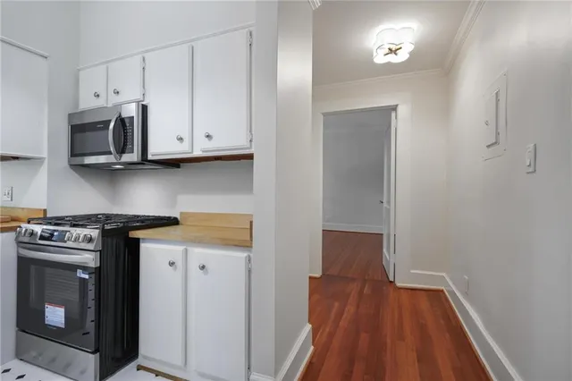 a kitchen with stainless steel appliances a stove a microwave and cabinets