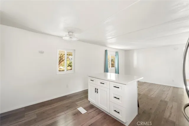an empty room with windows and cabinet