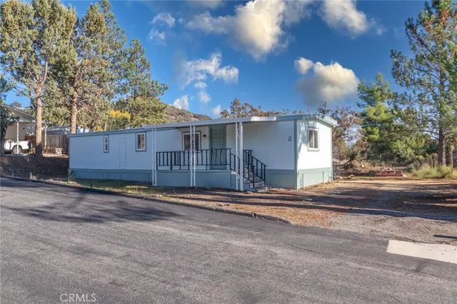 a view of a house with a yard and tree s