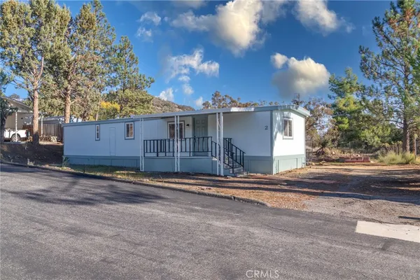 a view of a house with a yard and tree s