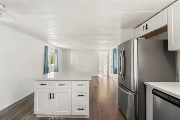 an entryway with wooden floor windows and cabinet