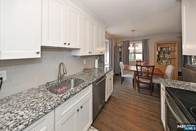 a kitchen with granite countertop lots of counter top space and wooden floor