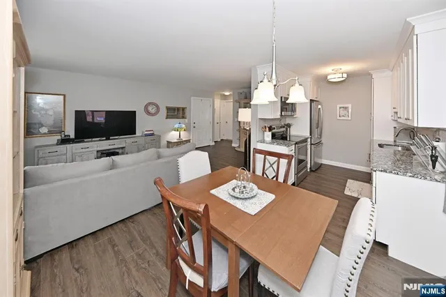 a view of a dining room with furniture a chandelier and wooden floor