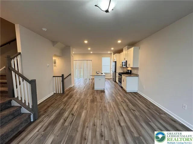 a view of a kitchen with wooden floor and electronic appliances