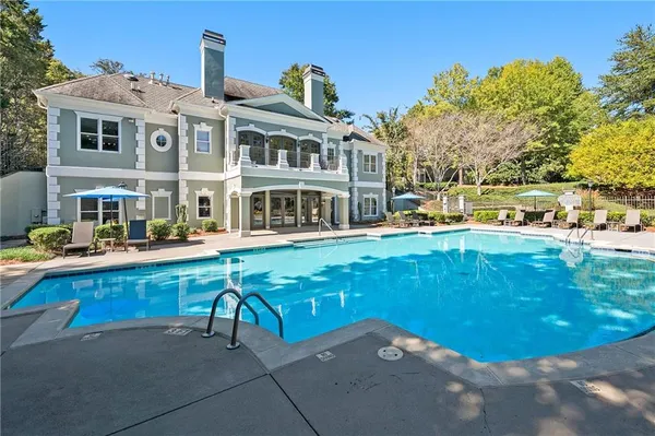 a view of a swimming pool with a bench in front of house