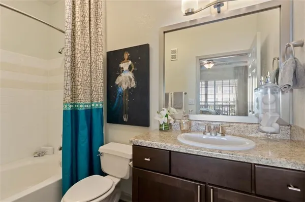 a bathroom with a granite countertop sink toilet and shower