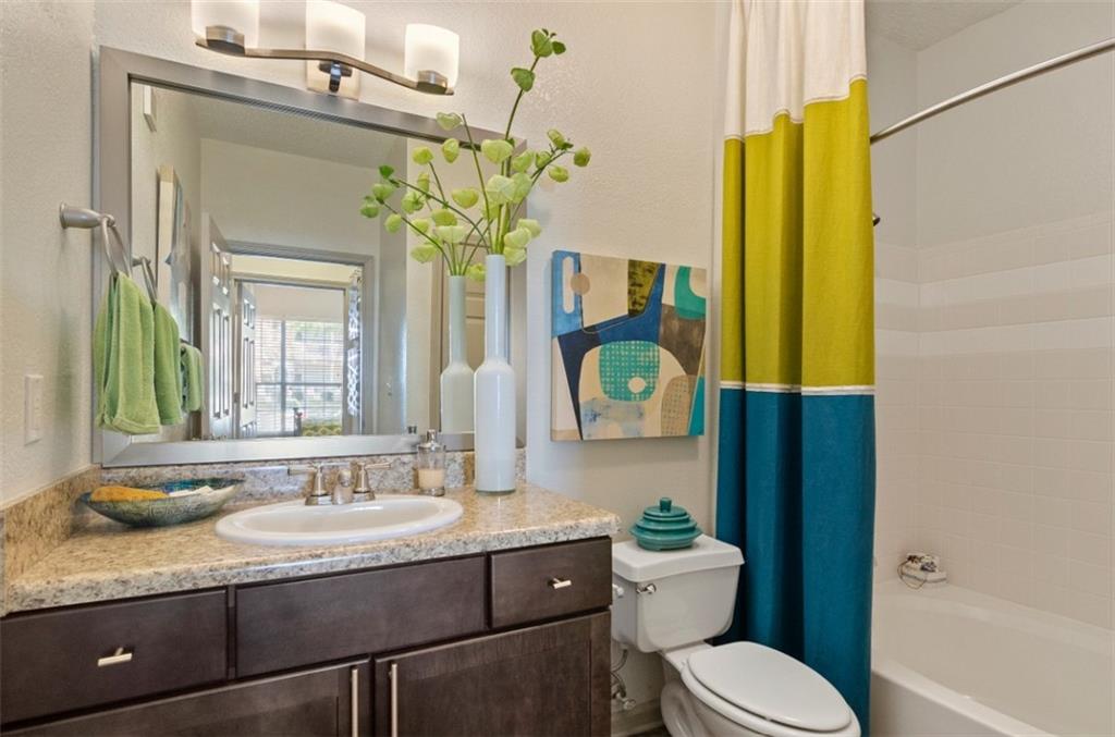 10055 Jones Bridge Road, Unit 206 Johns Creek, GA 30022 - Photo 10 of 28 a bathroom with a granite countertop toilet sink and mirror