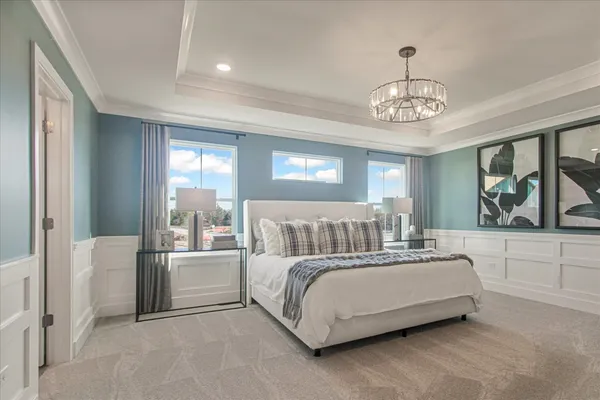 a large bedroom with a large bed and a chandelier
