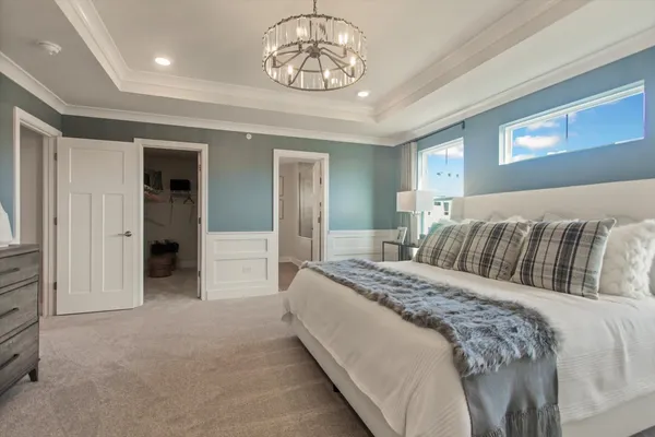 a spacious bedroom with a bed and a chandelier