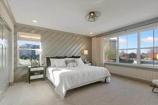 a bedroom with a bed and a large window