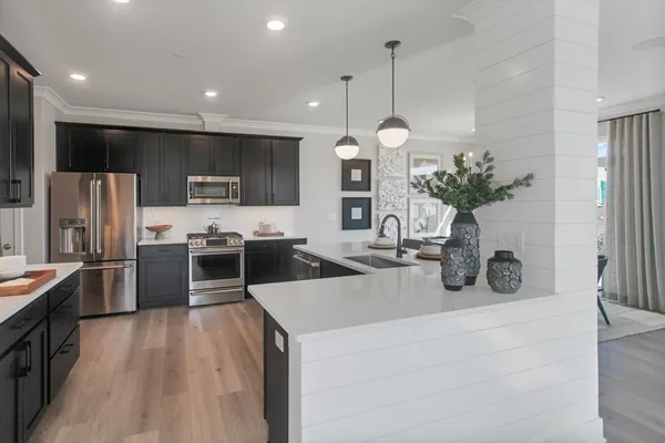 a kitchen with stainless steel appliances a refrigerator sink and stove