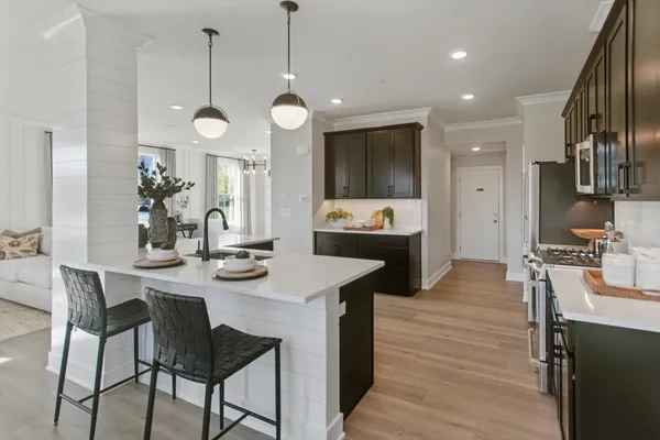 a kitchen with stainless steel appliances kitchen island granite countertop a stove a sink and a refrigerator