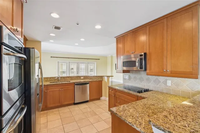 a kitchen with stainless steel appliances granite countertop a sink and a stove