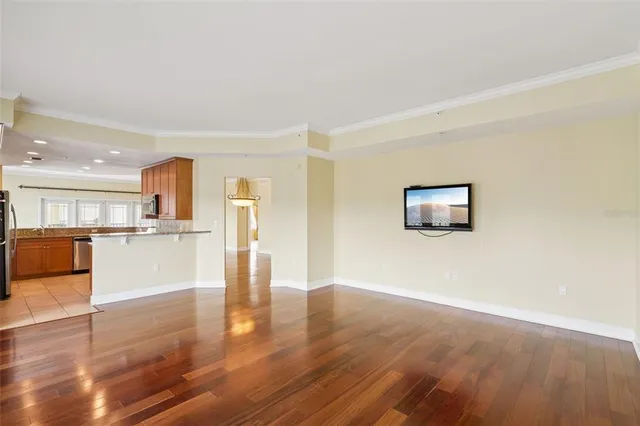 a view of a living room a kitchen with wooden floor and a kitchen view