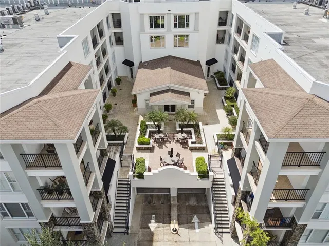 a view of a patio with couches table and chairs under an umbrella