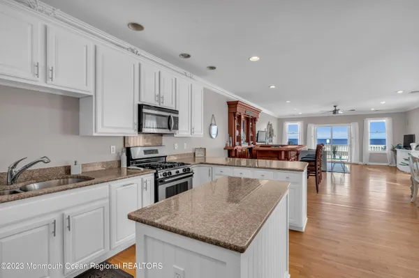 a kitchen with granite countertop a stove top oven a sink a counter space and cabinets