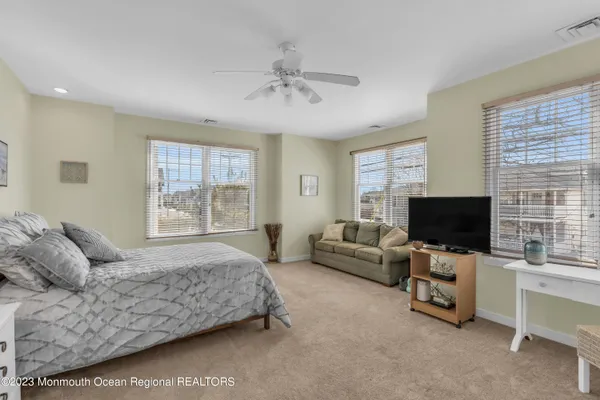 a spacious bedroom with a bed and a flat screen tv