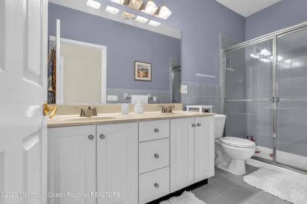 a bathroom with a double vanity sink mirror and toilet